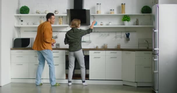 Junges gemischtes Paar kocht Tee zum Frühstück, hat Spaß zusammen — Stockvideo