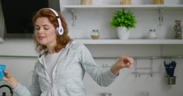 Jonge vrouw in romantische stemming is luisteren muziek in draadloze headset — Stockvideo