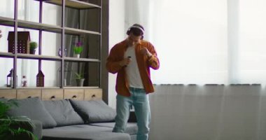 Genç latin adam kablosuz kulaklık müzik dinliyor ve dans ediyor