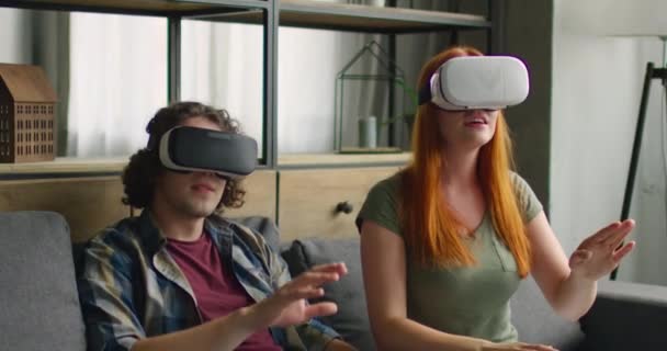 Ung kvinna och man njuter av sina nya VR-headset hemma — Stockvideo