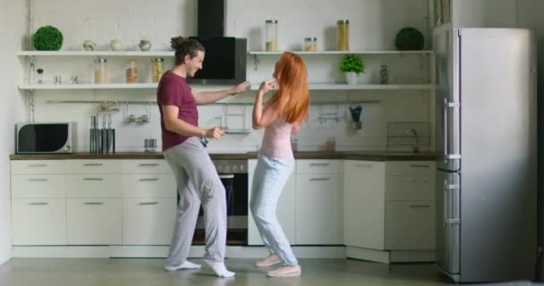 Mladý sladký pár tančí v nové kuchyni — Stock video