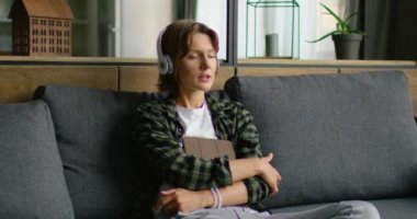 Genç kadın, kablosuz kulaklık yumuşak müzik dinlerken, onun hafta sonu sahiptir