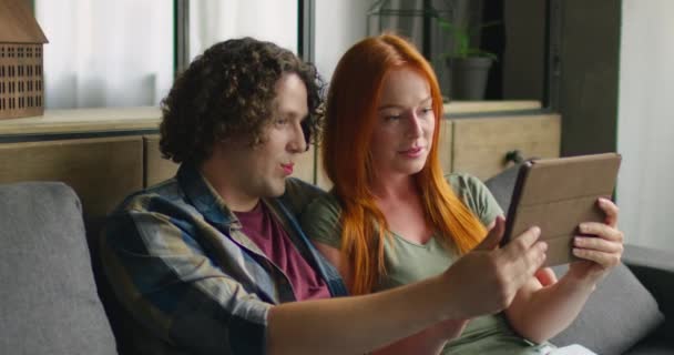 Молода жінка і чоловік мають відео чат, використовуючи планшетний комп'ютер — стокове відео