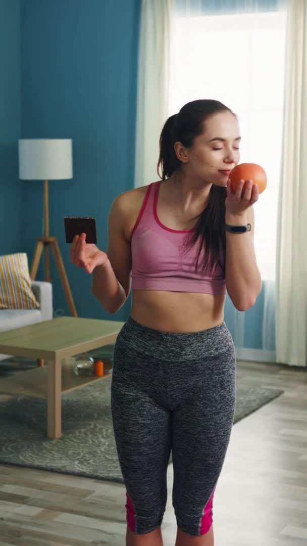 Vertical Portrait of Woman Making Choice between Chocolate and Grapefruit — Stock Video