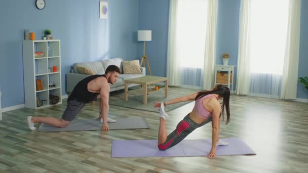 Mulher e homem praticam o alongamento da perna em casa — Vídeo de Stock