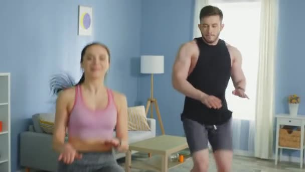 Hombre y mujer practican ejercicio cardiovascular, trotar en casa — Vídeo de stock