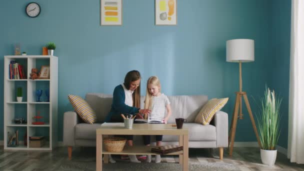 Mutter und kleine Tochter sind mit Lesen beschäftigt — Stockvideo