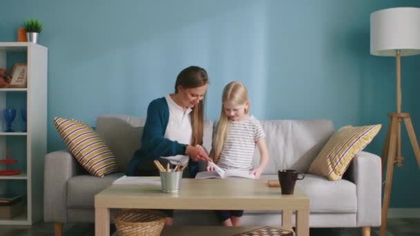 Madre e hija pequeña están leyendo juntas — Vídeos de Stock