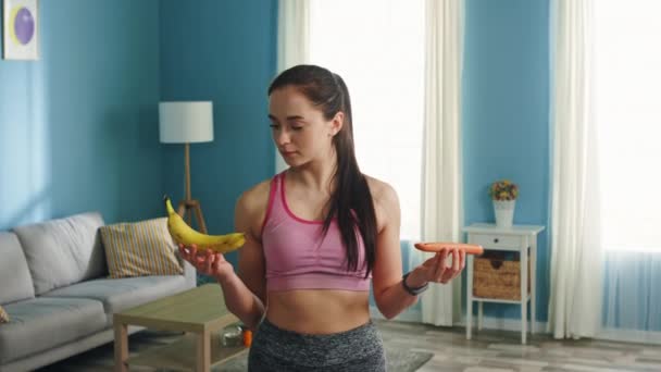 Retrato de mujer joven sosteniendo plátano y salchicha — Vídeos de Stock