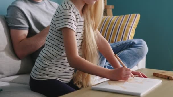 Piccola figlia è disegno mentre papà è occupato con la sua gadget — Video Stock