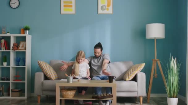 Far ska läsa boken med sin dotter. — Stockvideo