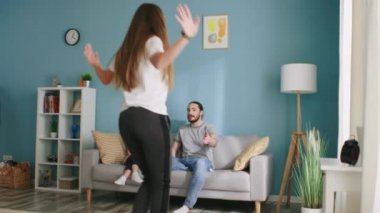 Kadın ailesiyle pandomim yapıyor.