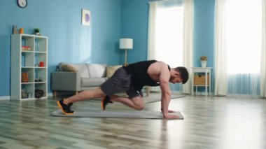 Genç adam dağ tırmanışı egzersizi yapıyor.