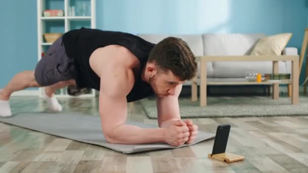 Athletic Man står i armbåge Plank hemma — Stockvideo