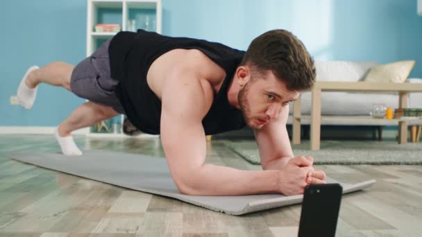 Atletik Adam Plank 'ta Duruyor ve Gadget Kullanıyor — Stok video