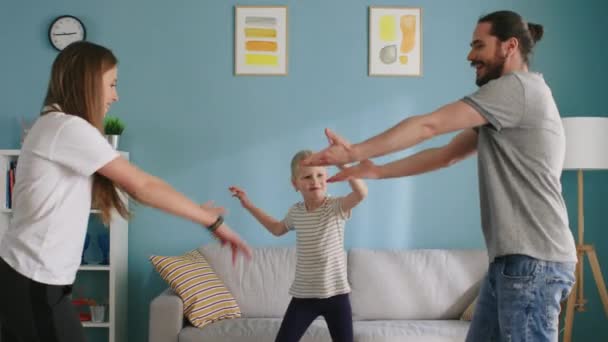 小さな女の子は両親と踊っている — ストック動画