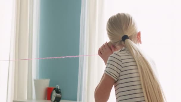 Liten flicka har roligt att använda papper Cup telefon — Stockvideo