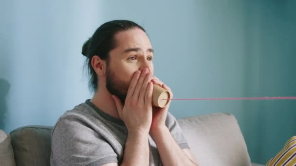 Le jeune homme s'amuse à utiliser le téléphone Paper Cup — Video