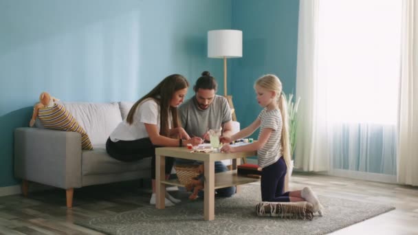 Jonge familie tekent in de woonkamer — Stockvideo