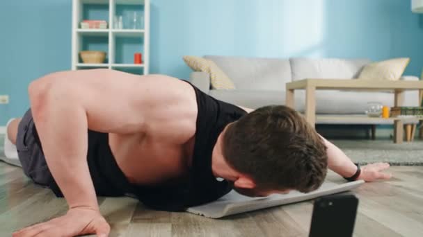 Hombre fuerte está haciendo ejercicio intestinal en casa — Vídeos de Stock