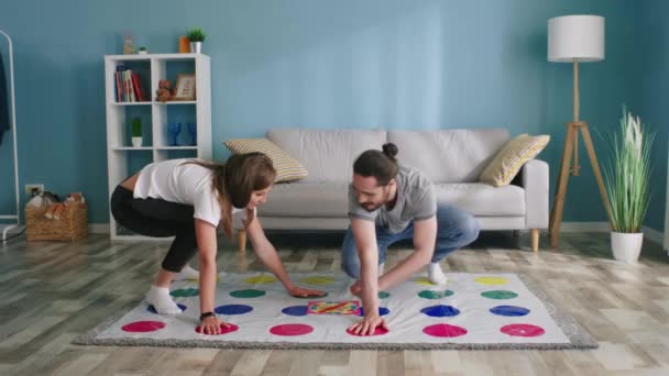 Genç adam ve kadın evde Twister oyunu oynuyorlar. — Stok video