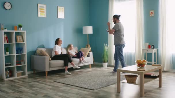 Paar en hun dochter vermaken zich in de woonkamer — Stockvideo