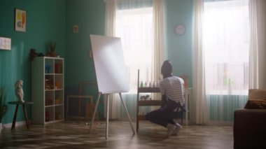 Genç siyah kadın resim yapacak.