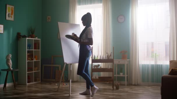 Joven mujer negra comienza a pintar sobre lienzo — Vídeos de Stock