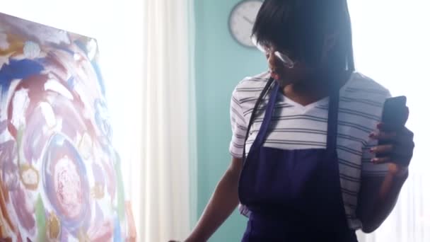 Zwarte vrouw is schilderen en filmen video — Stockvideo