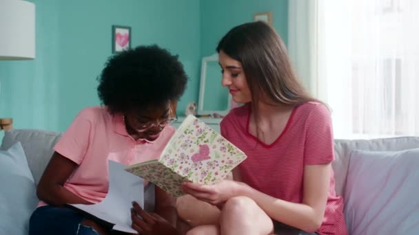 Twee jonge studenten vrouwen doen huiswerk — Stockvideo