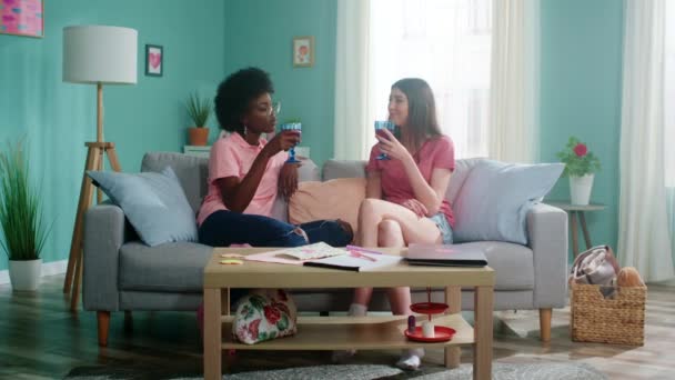 Две молодые женщины отдыхают в гостиной — стоковое видео