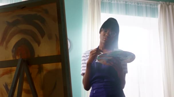 Zwarte vrouw in glazen is schilderen — Stockvideo