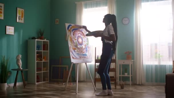Zwarte vrouw schildert op doek en dansen — Stockvideo