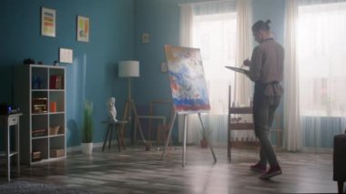 Genç Adam Güzel Stüdyo 'da tuvale resim yapıyor.