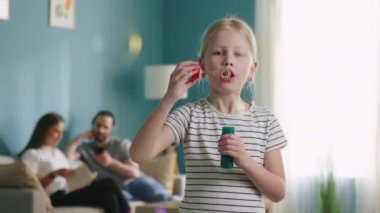 Mutlu küçük kız evde kabarcıklar çıkarıyor.