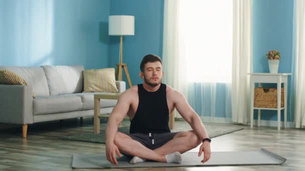 Молодий чоловік сидить у позі лотоса — стокове відео