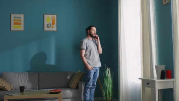 Ο άνθρωπος στέκεται κοντά στο παράθυρο και μιλώντας στο τηλέφωνο — Αρχείο Βίντεο
