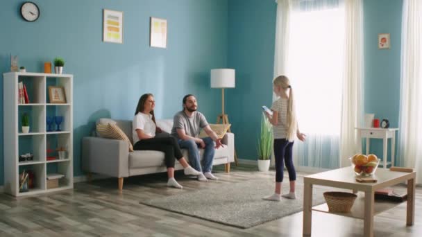 Menina pequena entreter na sala de estar com os pais — Vídeo de Stock