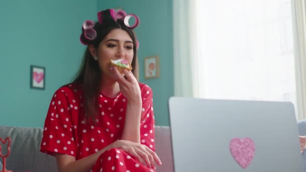 Snygg kvinna äter tårta titta på film — Stockvideo