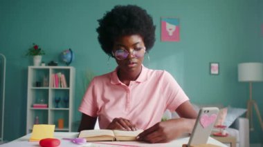 Afro-Amerikalı Kadın Okuyor ve Kameraya Bakıyor