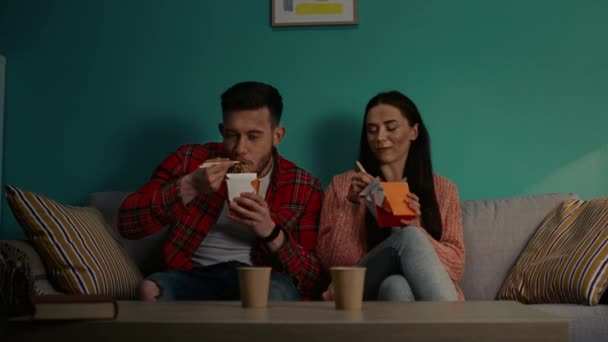 Kvinna och man äter spaghetti från papperslådor — Stockvideo