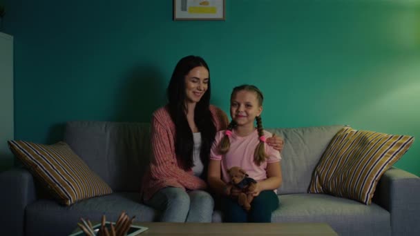 Retrato de niña y mujer joven sentadas en un sofá — Vídeos de Stock