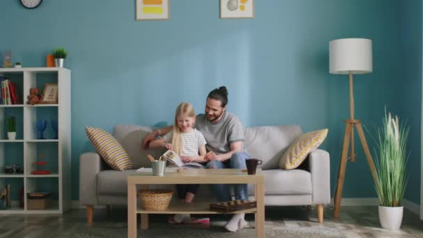 Papá y la hija pequeña leer libro — Vídeos de Stock