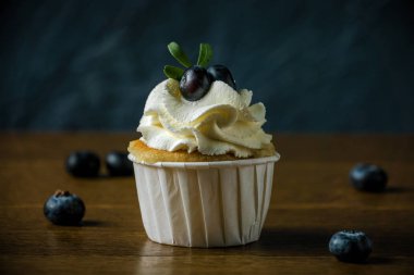 Delisious kek krem ve çilek ile bir taş koyu arka plan.