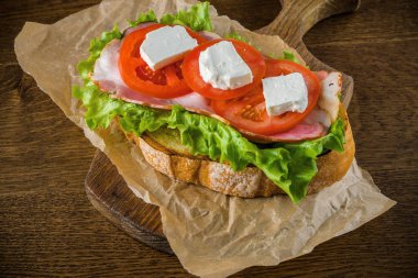 Koyu sırtlı ahşap masada lezzetli sandviç ve bira bira