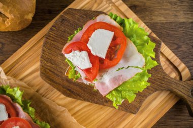 Koyu sırtlı ahşap masada lezzetli sandviç ve bira bira