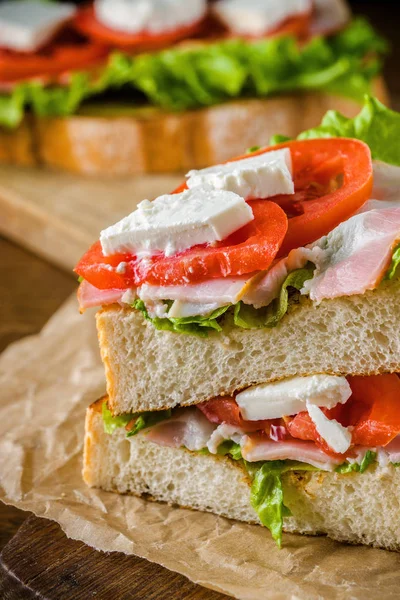 Läcker smörgås och lager öl på träbord med mörk rygg — Stockfoto