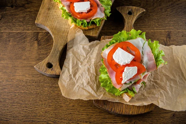 Koyu sırtlı ahşap masada lezzetli sandviç ve bira bira