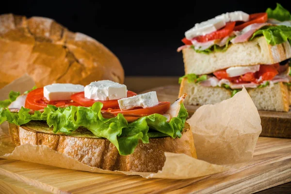 Leckeres Sandwich und Lagerbier auf Holztisch mit dunklem Rücken — Stockfoto