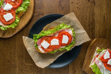 Koyu arka plan ile ahşap masada lezzetli sandviçler.